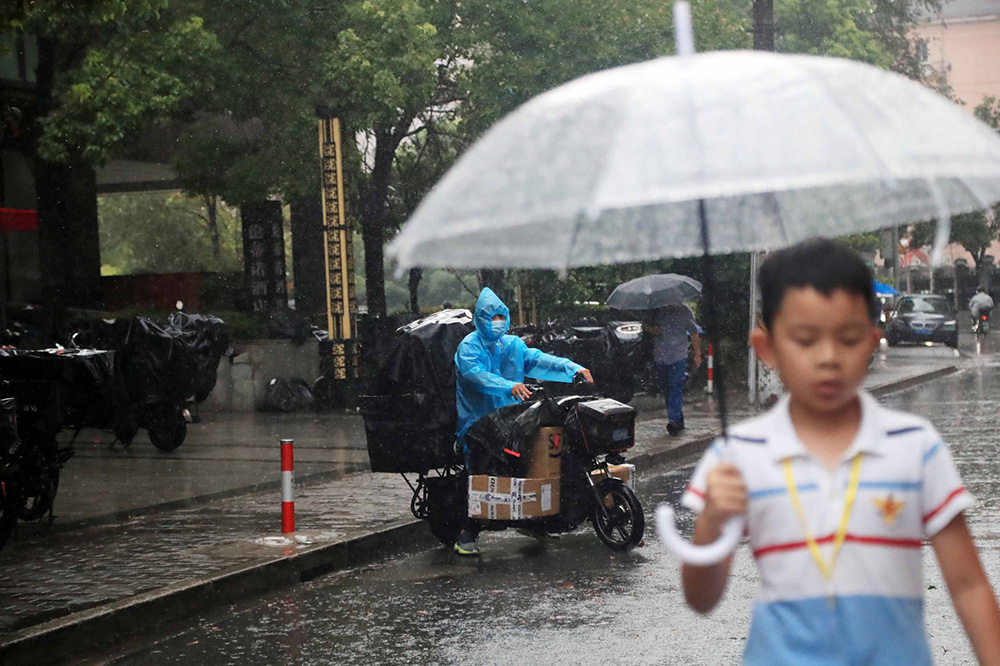 2022年9月5日，上海，受台风“轩岚诺”影响，市民冒雨出行。IC 图
